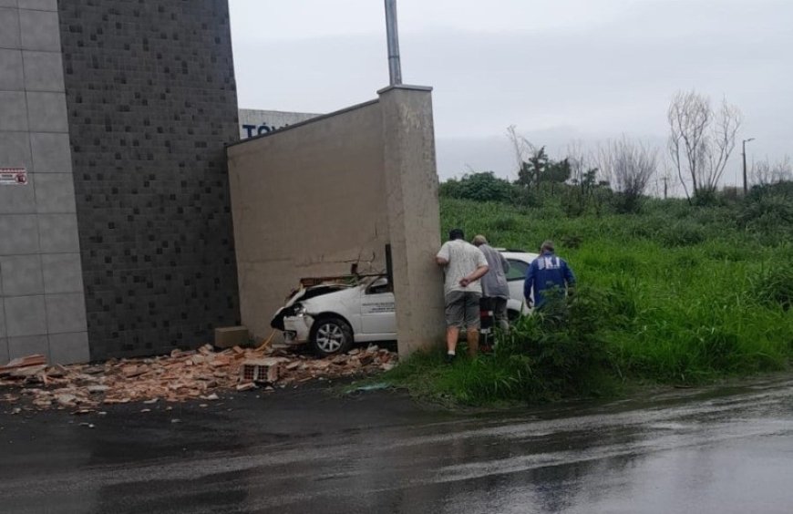 Carro da Secretaria de Saúde de Divinópolis atravessa muro após motorista perder controle da direção durante chuva